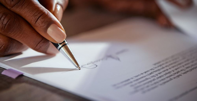 Woman's hand signing paper